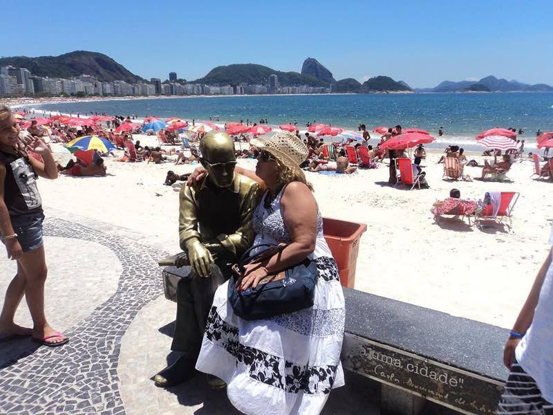 REGINA LOIRA sentada ao lado de DRUMOND na praia do Rio de Janeiro dep...